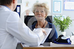 Senior woman on appointment in hospital listen to doctors prescription