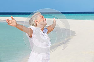 Senior Woman With Arms Outstretched On Beautiful Beach