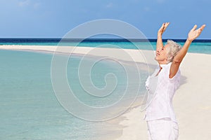 Senior Woman With Arms Outstretched On Beautiful Beach photo