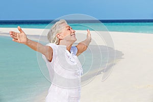Senior Woman With Arms Outstretched On Beautiful Beach photo