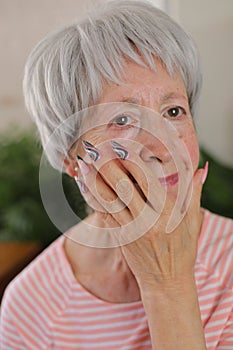 Senior woman with artsy multicolored long nails