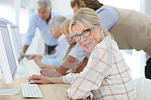 Senior woman attending training class with others