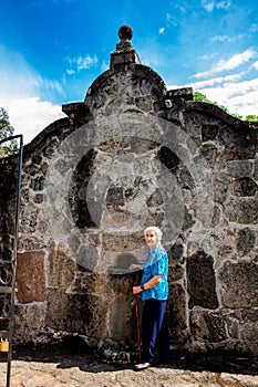 Senior woman at the beautiful historical church La Ermita built in the sixteenth century in the town of Mariquita in Colombia photo