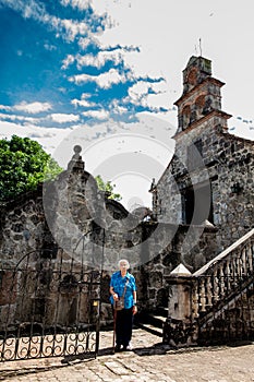 Senior woman at the beautiful historical church La Ermita built in the sixteenth century in the town of Mariquita in Colombia photo