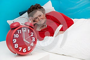Senior woman in bed ill and suffered of sleeplessness or insomnia.