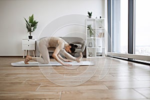 Senior woman in beige sport attire having active workout.