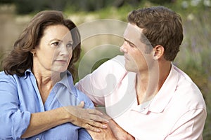 Senior Woman Being Comforted By Adult Son photo