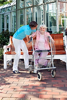 Senior woman being helped by a care assistant.