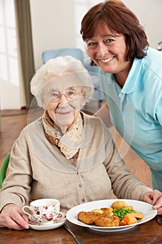 Senior Woman Being Served Meal By Carer