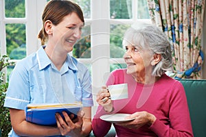 Senior Woman Being Visited By Carer At Home