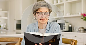 Senior woman, bible study and reading for religion, knowledge and connection to God for retirement in house. Elderly