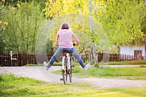 Senior woman with bicycle outside in spring nature.