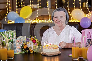 Senior woman with birthday cake at anniversary or Mothers Day party