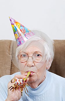 Senior Woman With Birthday Hat And Noise Maker