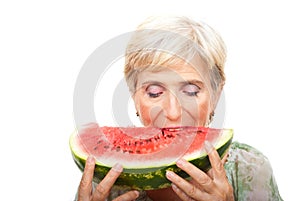 Senior woman biting watermelon