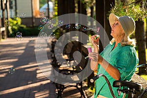 Senior woman blowing bubbles.