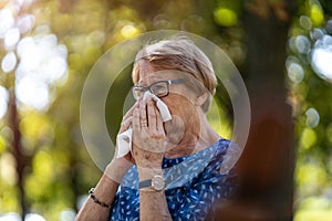 Senior woman blowing her nose