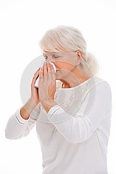 Senior woman blowing her nose