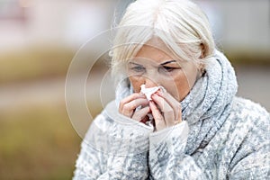 Senior woman blowing her nose