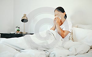 Senior woman, blowing nose and sick in bed with allergy, virus from bacteria with health and wellness at home. Sinus