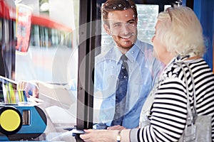 Senior Woman Boarding Bus And Buying Ticket