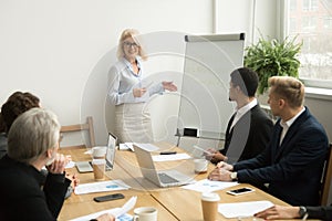 Senior woman boss leading corporate team meeting or giving prese