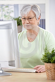 Senior woman browsing internet at home photo