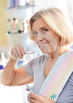 Senior woman brushing her teeth