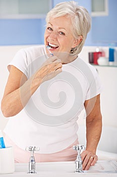 Senior woman brushing teeth