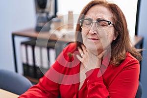 Senior woman business worker suffering for throat pain at office