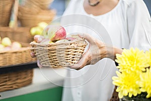 Senior woman buying apples in punnet on market