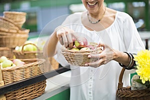 Senior woman buying apples in punnet on market