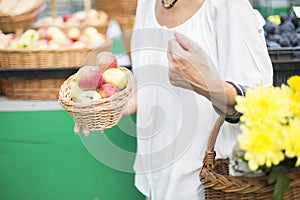 Senior woman buying apples in punnet on market