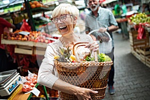 Senior woman buying fresh fruits and vegetables at the local market