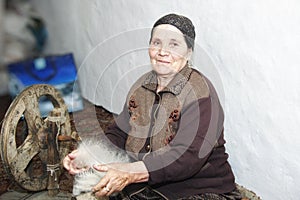 Senior woman carding woollen yarn photo