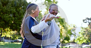 Senior, woman and caregiver with arm stretching for exercise, workout or fitness in a park with smile. People