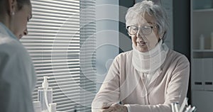 Senior woman with cervical collar in the doctor`s office
