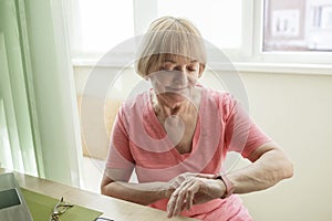 Senior woman checking health information using smart watch, modern healthcare and support