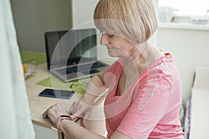 Senior woman checking health information using smart watch, modern healthcare and support