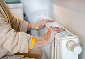 Senior woman checking heating radiator