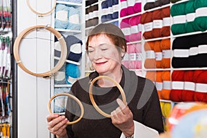 Senior woman choosing embroidery hoops for fancywork photo