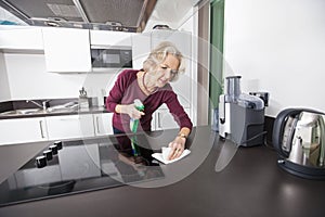 Senior woman cleaning kitchen counter