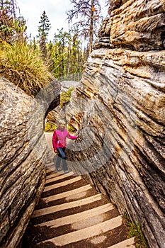 Senior woman climbing the steep stairway that goes from the top of the Athabasca Falls to the canyo