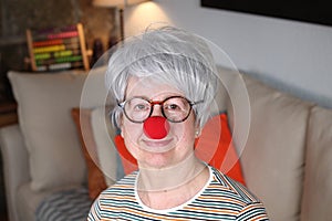 Senior woman with clown red nose