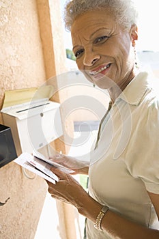 Senior Woman Collecting Letter From Mailbox photo