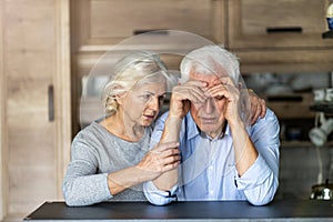 Senior woman comforting her husband