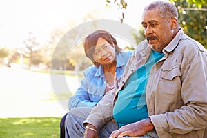 Senior Woman Comforting Unhappy Senior Husband Outdoors