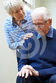 Senior Woman Comforts Husband Suffering With Parkinsons Diesease