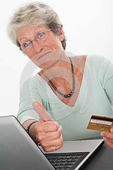 Senior woman on a computer with a credit card
