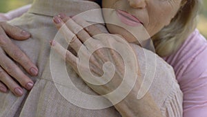 Senior woman condolencing to man about disease or loss, support, care, closeup